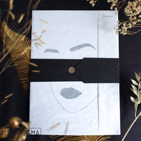 Emballage cadeau prêt à offrir de l'affiche Carmen, papier de soie blanc et ceinture noire.
