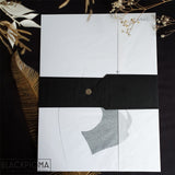 Emballage cadeau de l'affiche Helena, papier de soi blanc et ceinture de soie noire, prête à offrir.