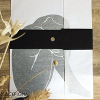 Packaging de l'affiche minimaliste Ava, dans du papier de soie noir et blanc