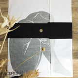 Packaging de l'affiche minimaliste Ava, dans du papier de soie noir et blanc